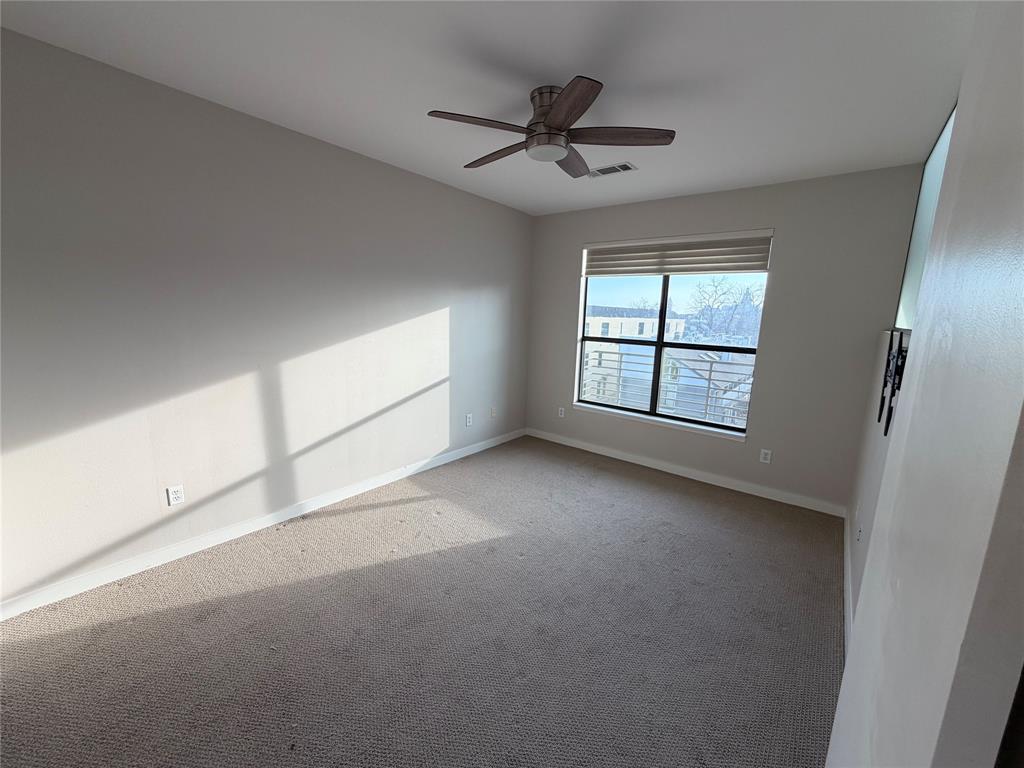 4040 North Hall Street, Unit 309 Dallas, TX 75219 - Photo 4 of 18 an empty room with windows and ceiling fan