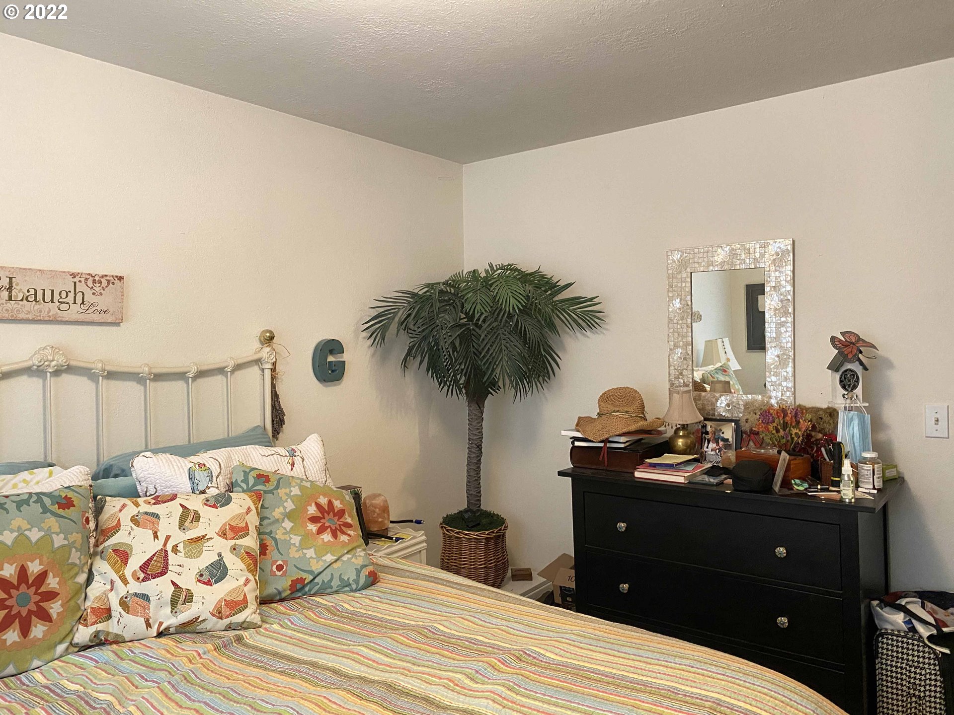 2222 11th Street Florence, OR 97439 - Photo 12 of 32 a bedroom with a bed and a potted plant