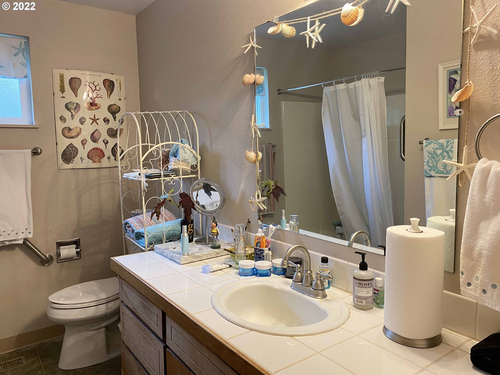 2222 11th Street Florence, OR 97439 - Photo 13 of 32 a bathroom with a sink a toilet and a mirror