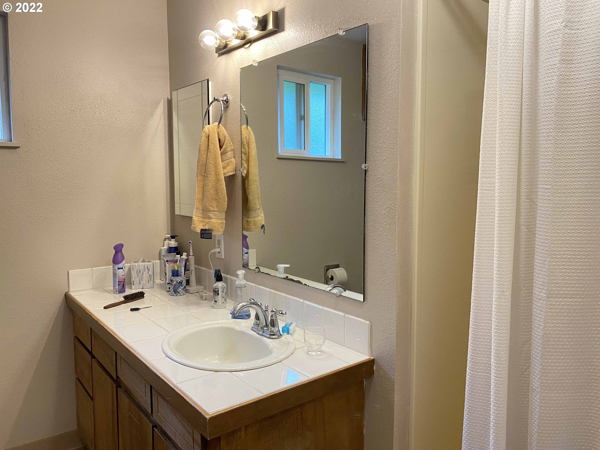2222 11th Street Florence, OR 97439 - Photo 17 of 32 a bathroom with a sink and a mirror