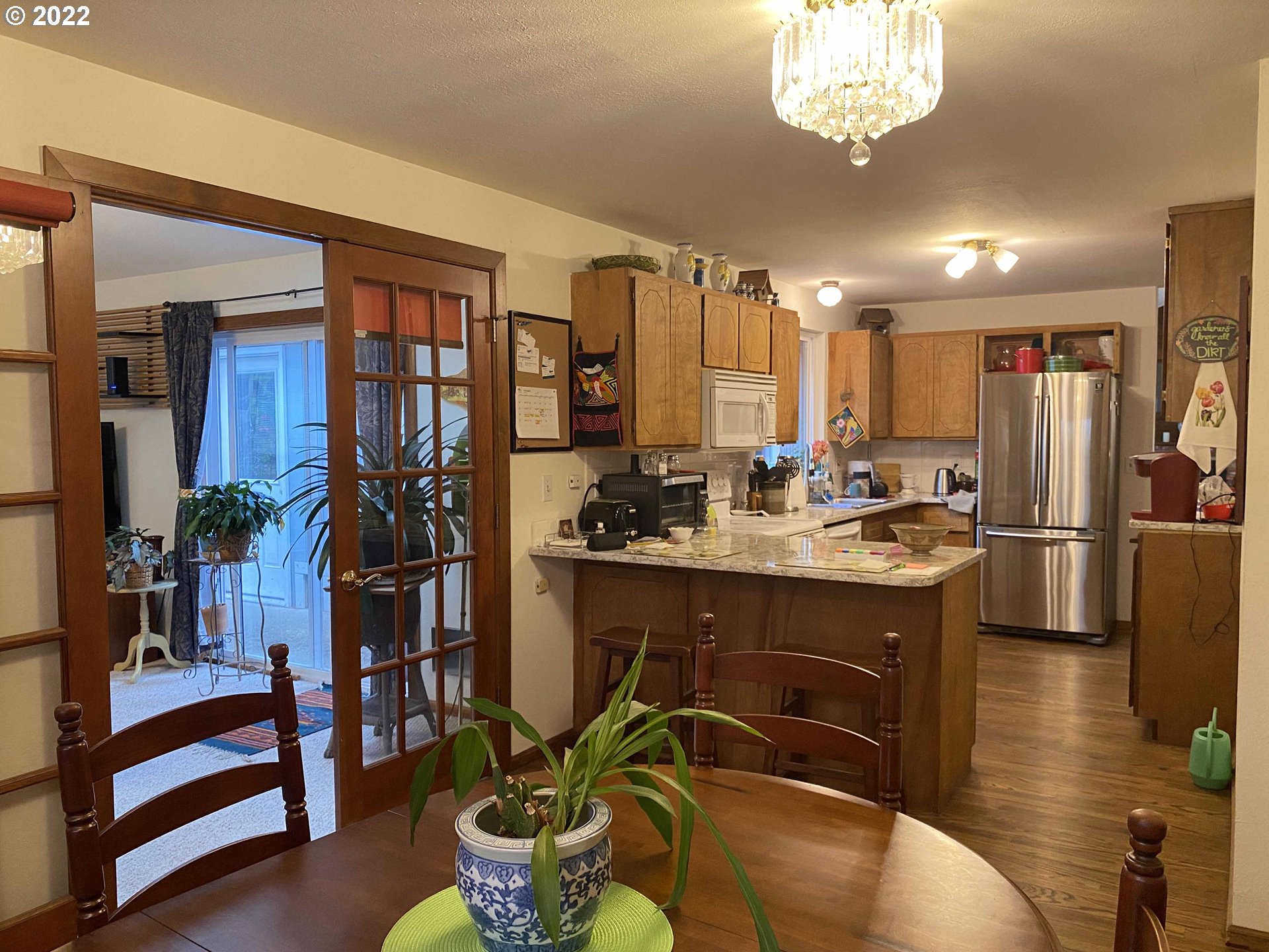 2222 11th Street Florence, OR 97439 - Photo 21 of 32 a kitchen with stainless steel appliances kitchen island granite countertop a refrigerator a stove a sink and a dining table with wooden floor