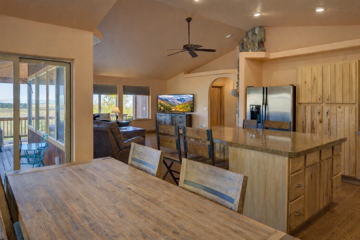 155 Lamb Mountain Road Fairplay, CO 80440 - Photo 11 of 48 Kitchen featuring arched walkways, a kitchen island, vaulted ceiling, stainless steel fridge with ice dispenser