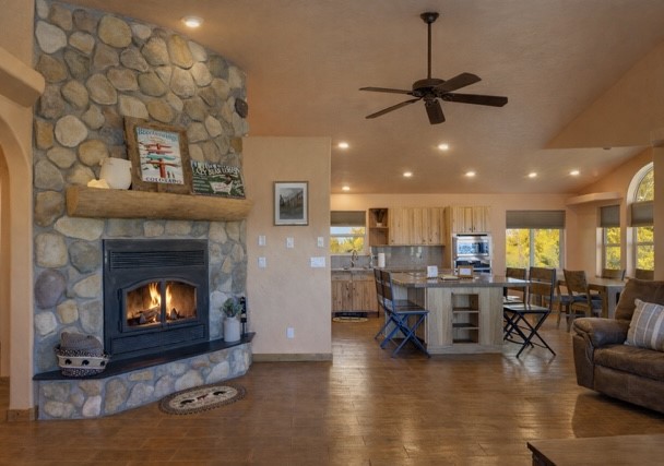 155 Lamb Mountain Road Fairplay, CO 80440 - Photo 6 of 48 Living room featuring a stone fireplace, dark wood-style flooring, recessed lighting, a ceiling fan, and vaulted ceiling
