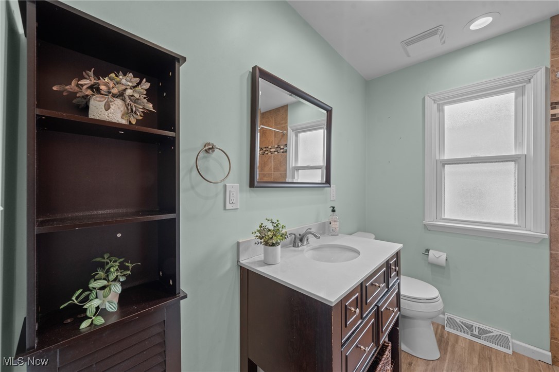 6315 Brookside Road Independence, OH 44131 - Photo 18 of 41 Bathroom featuring toilet, baseboards, visible vents, and wood finished floors