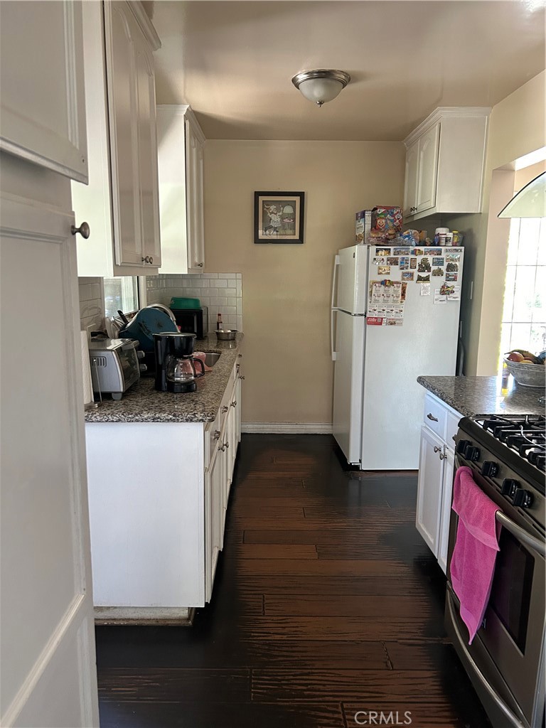 6720 Sherman Way Bell, CA 90201 - Photo 7 of 15 a kitchen with a refrigerator stove and wooden floor