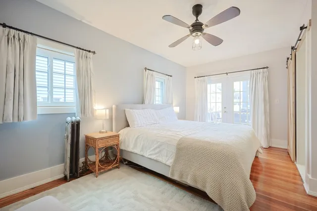 a bedroom with a bed chandelier and a window