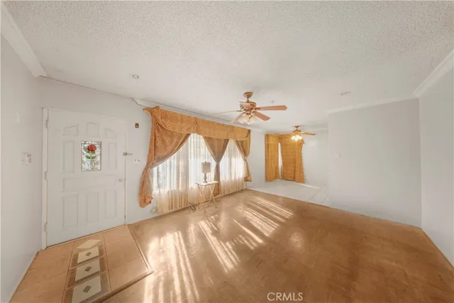 a view of a livingroom with wooden floor and a ceiling fan