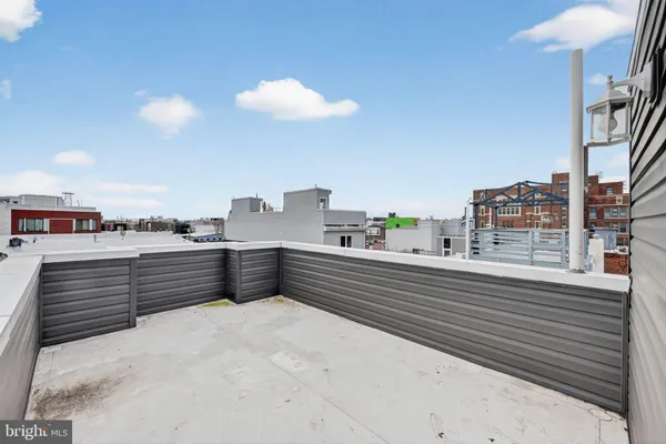 a roof deck with couch and chairs