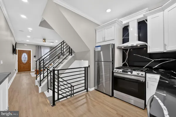 a kitchen with stainless steel appliances granite countertop a refrigerator stove a sink and dishwasher with wooden floor