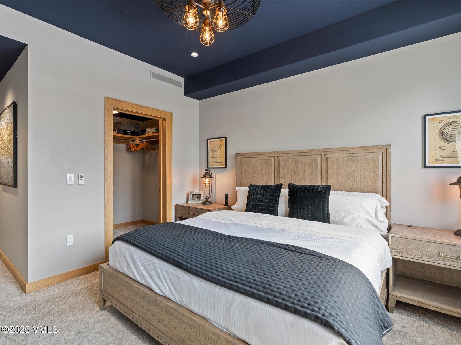 1 Waterfront Way, Unit 204 Avon, CO 81620 - Photo 20 of 38 a bedroom with a large bed and a chandelier