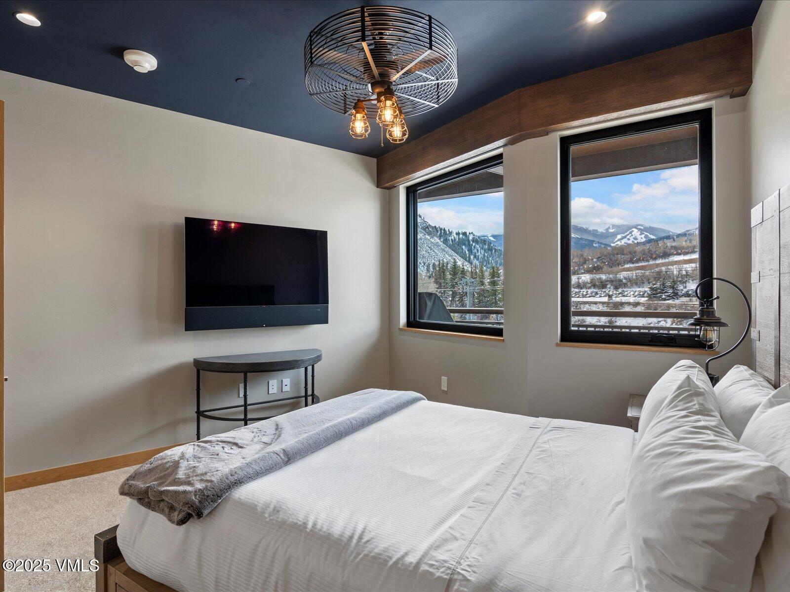 1 Waterfront Way, Unit 204 Avon, CO 81620 - Photo 25 of 38 a bedroom with a bed and a flat screen tv