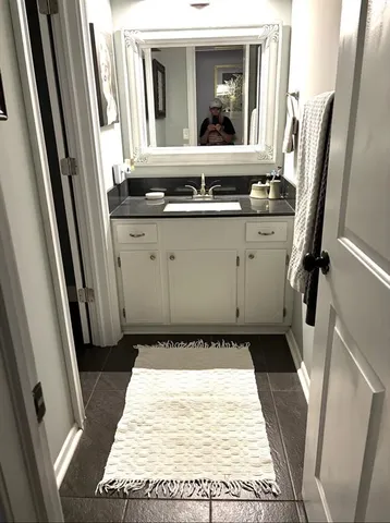 a bathroom with a granite countertop sink and a mirror