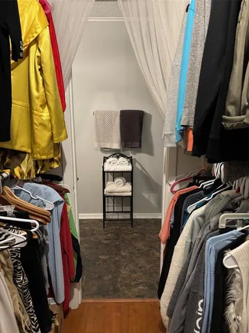 a view of walk in closet with clothes and shoes