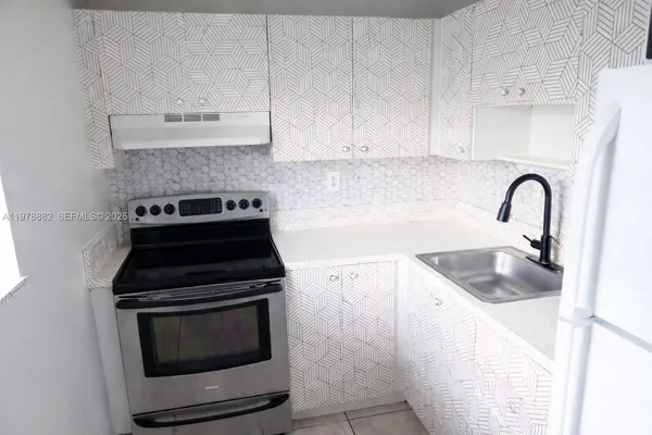 a kitchen with granite countertop a stove and a sink
