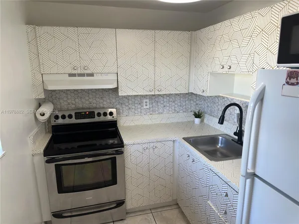a kitchen with cabinets and refrigerator