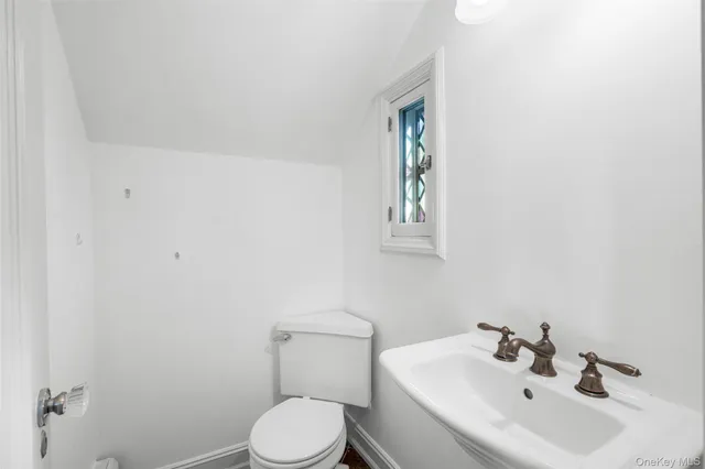a bathroom with a sink a toilet and mirror
