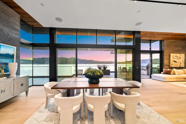 a view of a dining room with furniture large windows and wooden floor