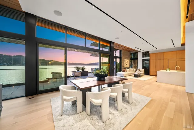 a large room with stainless steel appliances kitchen island granite countertop a large kitchen counter top space a sink a refrigerator and windows