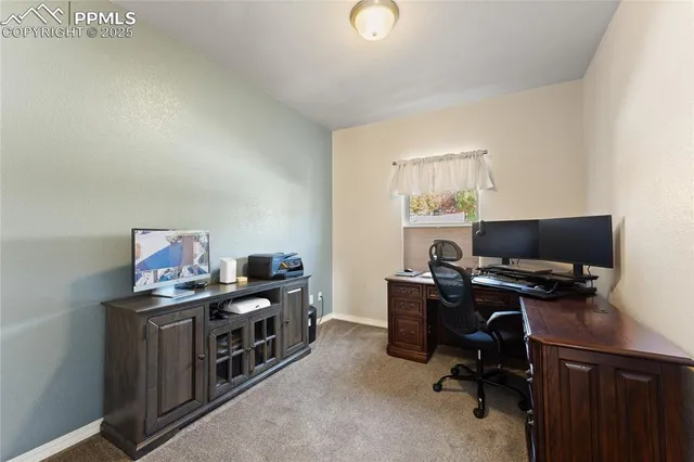 a view of a workspace with furniture and a window
