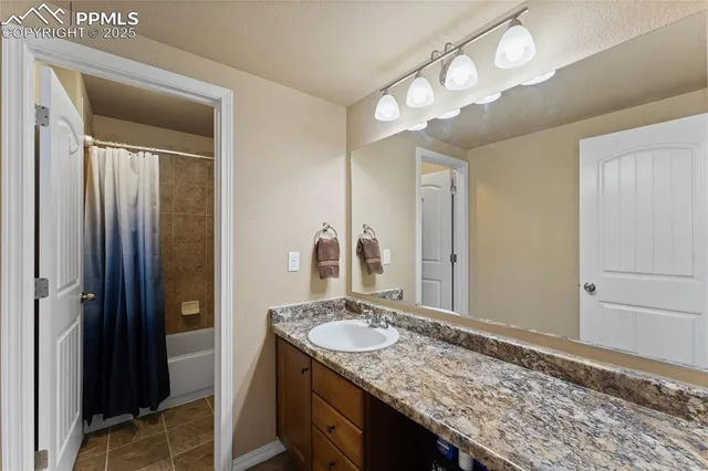 a bathroom with a granite countertop sink and a mirror