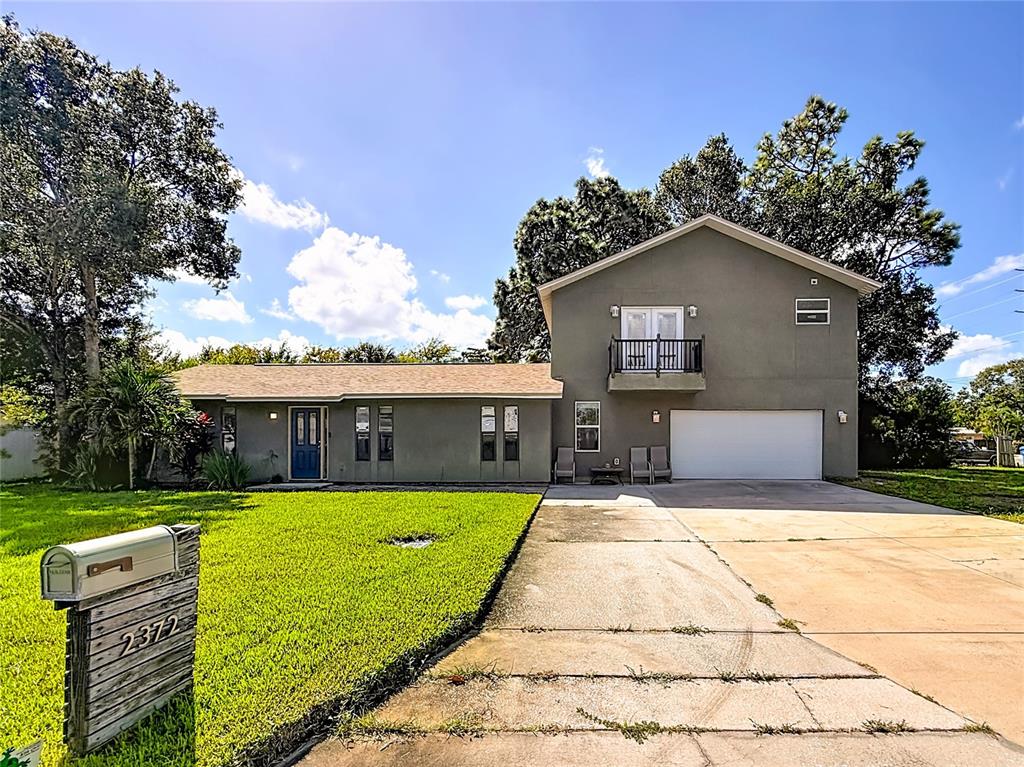 a front view of house with yard and trees in the background