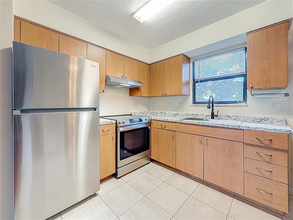 2372 18th Avenue Southwest Largo, FL 33774 - Photo 14 of 80 a kitchen with stainless steel appliances granite countertop a refrigerator sink and cabinets