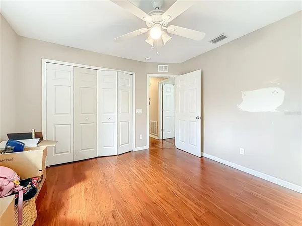 an empty room with wooden floor and windows