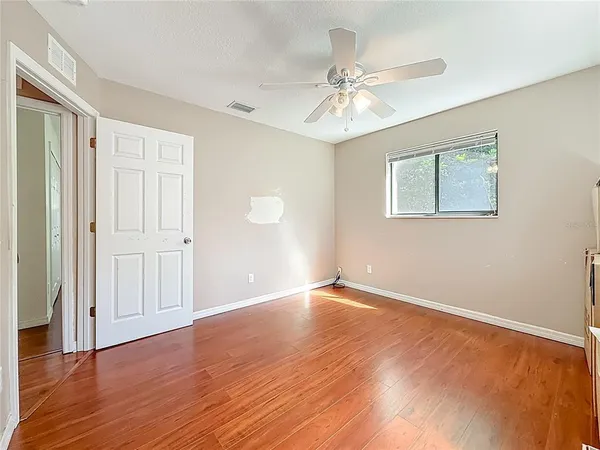 a view of empty room with wooden floor