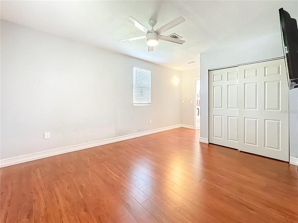 2372 18th Avenue Southwest Largo, FL 33774 - Photo 38 of 80 an empty room with wooden floor and ceiling fan