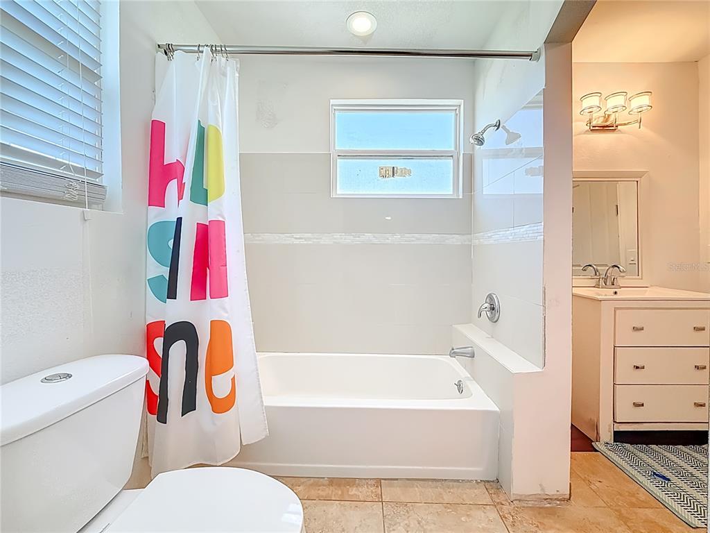 2372 18th Avenue Southwest Largo, FL 33774 - Photo 57 of 80 a bathroom with a bath tub a toilet and a shower curtain