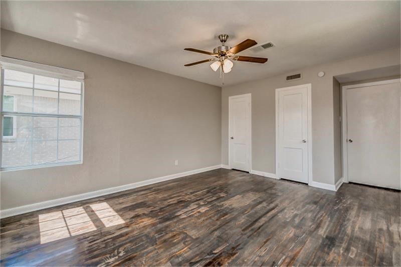 3502 Rosedale Street Houston, TX 77004 - Photo 7 of 17 Sleek hardwood floors, a ceiling fan for comfort, and ample natural light streaming through a large window.