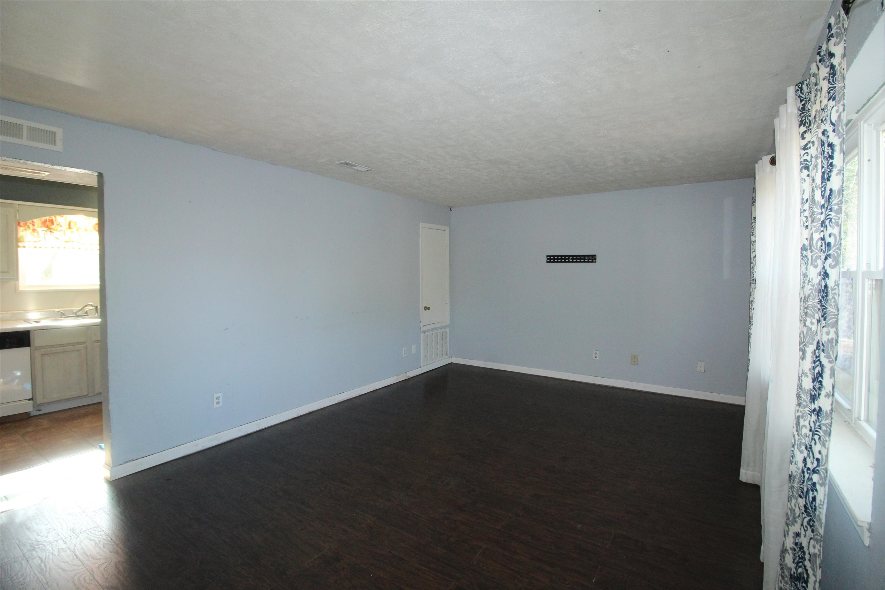 410 Lowery Road Medon, TN 38356 - Photo 3 of 24 an empty room with wooden floor and windows
