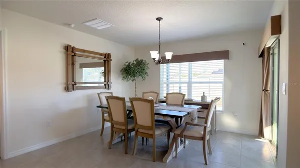 a kitchen with stainless steel appliances a refrigerator a stove a sink a dining table and chairs