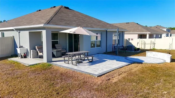 a view of a house with table and chairs under an umbrella