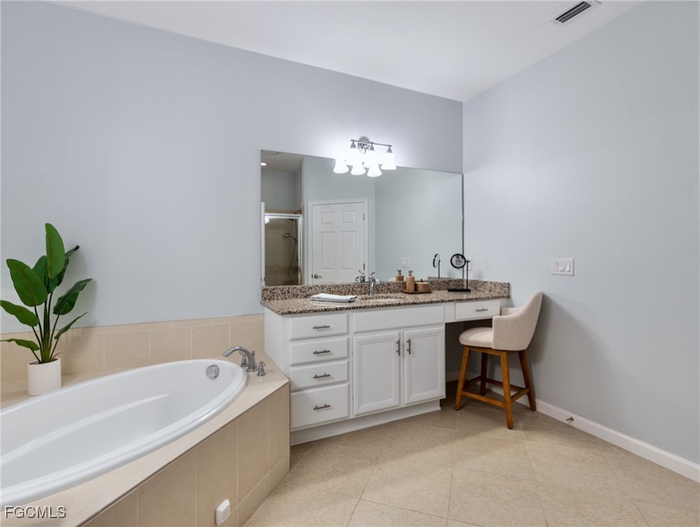 10260 Glastonbury Circle, Unit 102 Fort Myers, FL 33913 - Photo 28 of 44 a bathroom with a granite countertop bathtub a sink and a large mirror