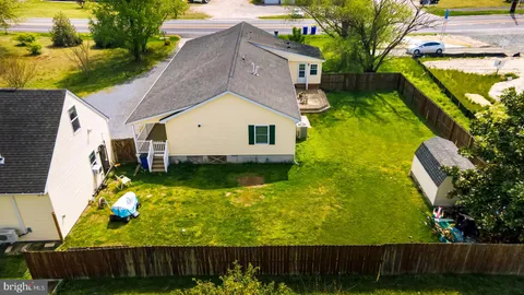 an aerial view of a house with swimming pool and large trees
