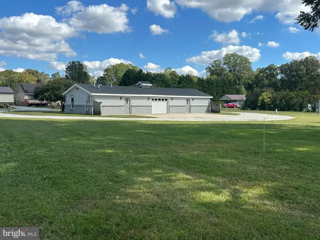 a front view of a house with a yard and trees