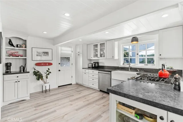 a kitchen with granite countertop a sink stainless steel appliances and cabinets