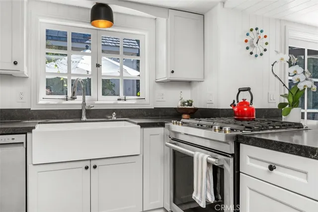 a kitchen with granite countertop white cabinets and white appliances