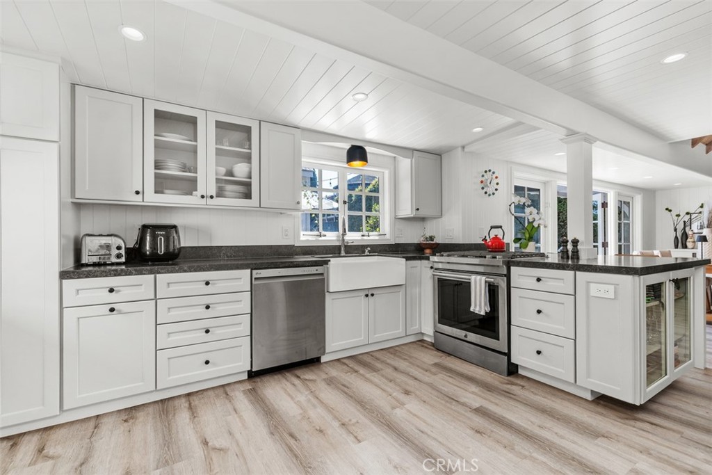 455 Brooks Street Laguna Beach, CA 92651 - Photo 14 of 32 a kitchen with granite countertop white cabinets and white appliances