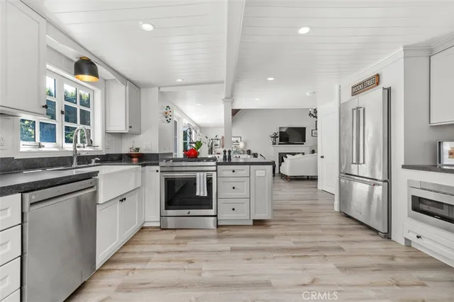 a kitchen with white cabinets and stainless steel appliances