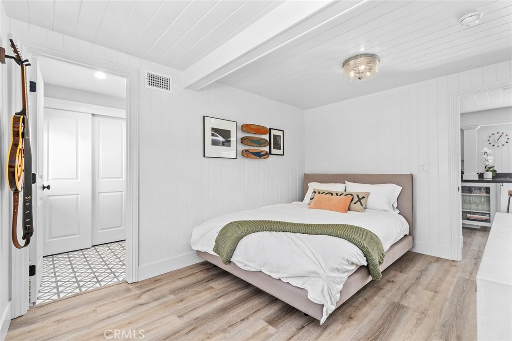 455 Brooks Street Laguna Beach, CA 92651 - Photo 17 of 32 a bedroom with a bed and a painting on the wall