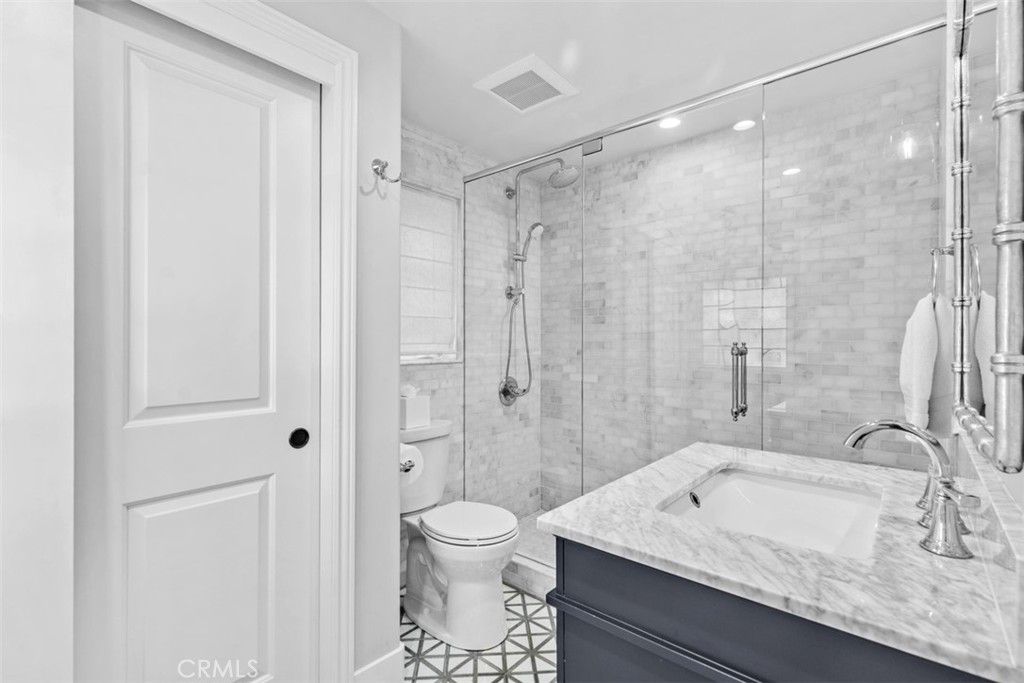 455 Brooks Street Laguna Beach, CA 92651 - Photo 19 of 32 a bathroom with a granite countertop sink a toilet and shower