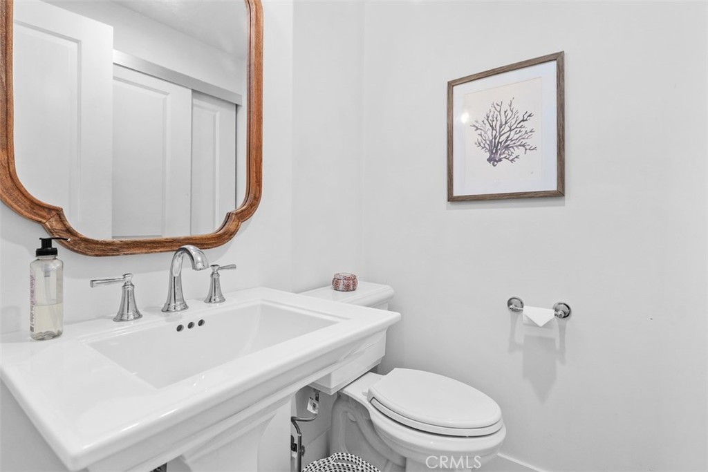 455 Brooks Street Laguna Beach, CA 92651 - Photo 21 of 32 a bathroom with a toilet a sink and mirror