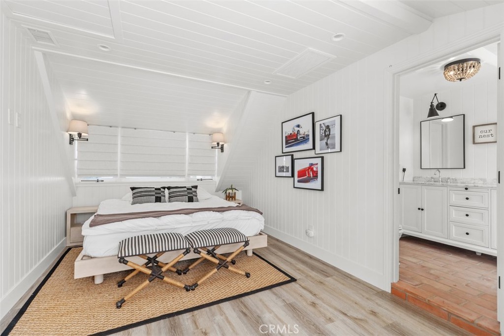 455 Brooks Street Laguna Beach, CA 92651 - Photo 22 of 32 a bedroom with a bed and wooden floor