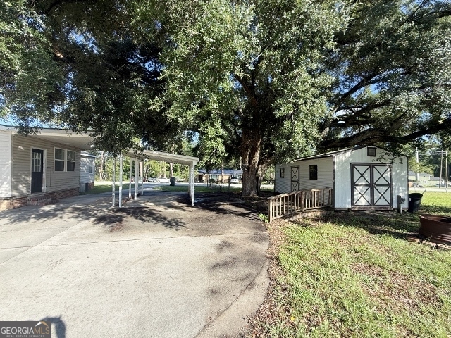 451 Lambs Bridge Road Swainsboro, GA 30401 - Photo 22 of 23 a row of palm trees in front of a house