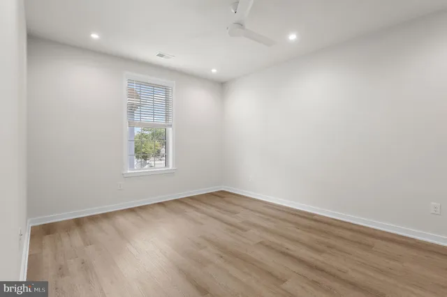 an empty room with wooden floor and white walls