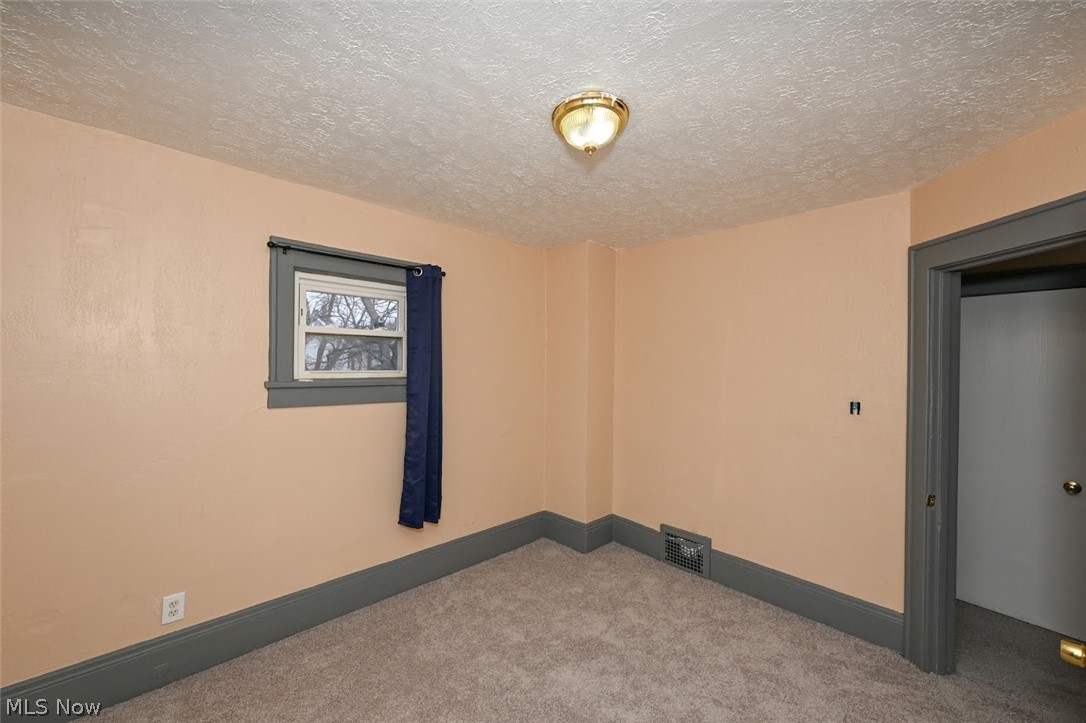 77 West Mildred Avenue Akron, OH 44310 - Photo 26 of 40 Carpeted spare room featuring a textured ceiling and baseboards