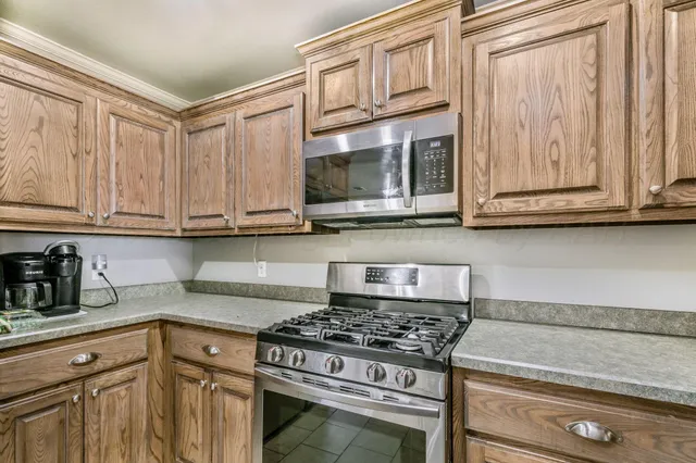 a kitchen with stainless steel appliances granite countertop a stove a microwave and cabinets