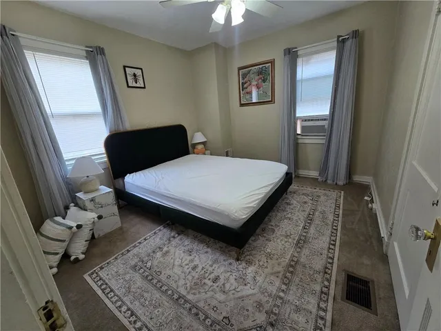 a bedroom with a bed rug and wooden floor